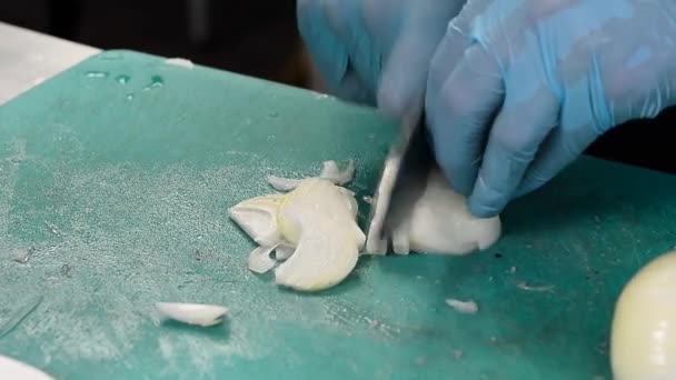 Cortar cebolla cruda en una mesa — Vídeos de Stock