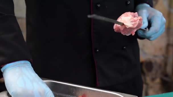 Chef sticks meat on skewer for roasting — Stock Video