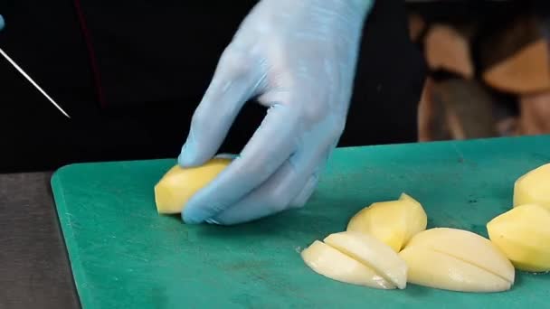 Skär färsk potatis i köket för matlagning — Stockvideo