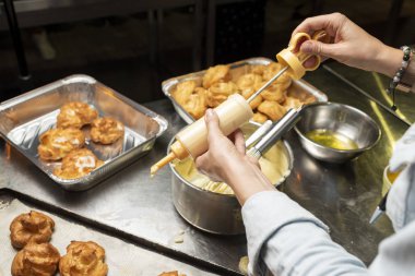 Mutfakta kadın elinde kremalı kek