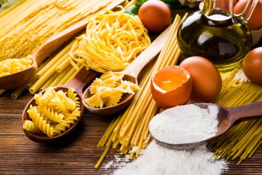 spagetti ve makarna üzerine yumurta ve un ve zeytinyağı içeren bir tablo