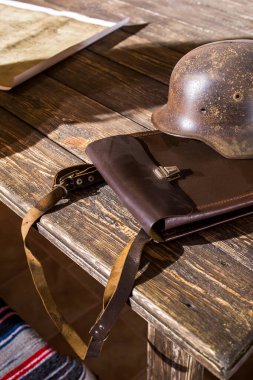 Askeri saha subayı tableti kasklı ve haritalı bir masada.