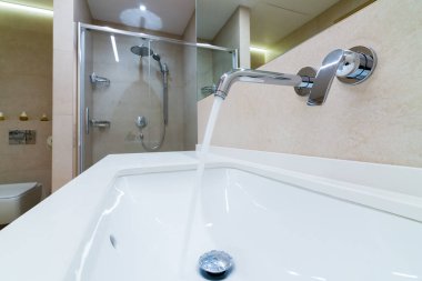 Banyodaki musluktan su akıyor.