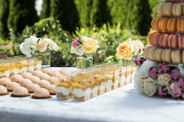 テーブルにはお花やマカロンケーキや軽食がテーブルに並べられています — ストック写真