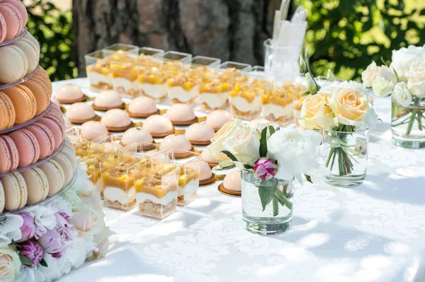 テーブルには花やマカロンケーキが飾られています — ストック写真