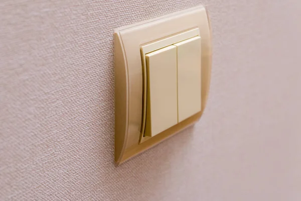 double coffee color light switch on the wall with wallpaper
