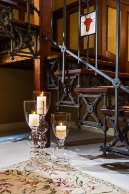 Lambalardaki mumlar ahşap merdivenlerin yanında.