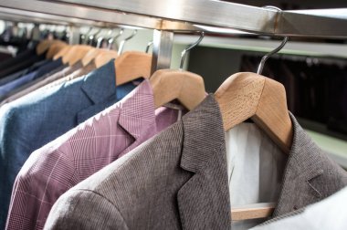 Askıdaki erkek ceketleri mağazadaki askılarda asılı takım elbiseler