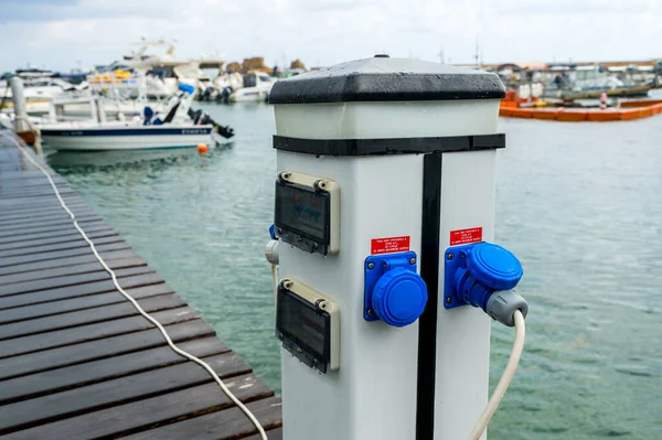 electrical outlets for charging on boats in the harbor background, horizontal frame