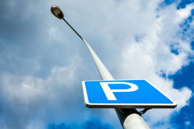 Gökyüzü arka planında bir direkte arabalar için park tabelası