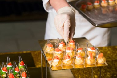 Plastik eldivenli bir şefin elinde hazır yemek.