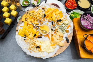 sert ve yumuşak peynirler fındık ve bal ile ahşap bir tabakta parşömen kağıdında bir ziyafet masasında, üst manzara