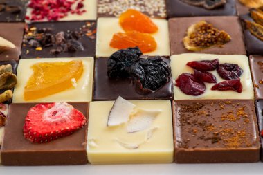 El yapımı koyu, sütlü ve beyaz çikolatalı fındıklı ve kuru meyveli.