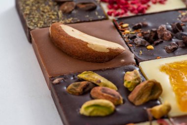 Süt, siyah ve beyaz çikolata, fındıklı ve kurutulmuş meyveler, farklı lezzetlerde.