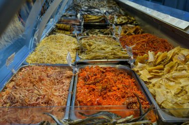 Mağazanın tezgahında füme ve kurutulmuş balık, mürekkep balığı, ringa balığı, sarı balina