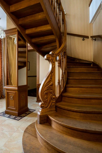 stock image spiral wooden steps with carved railing in the interior