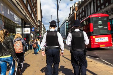Londra, İngiltere - 9 Haziran 2015: Oxford Street. Şehirde devriye geleneksel üniformalı iki tanınmaz halde polis memuru.