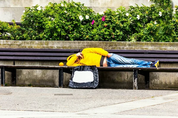 Unbekannter Arbeitsloser Gelber Jacke Mit Kapuze Und Blauer Jeans Liegt — Stockfoto