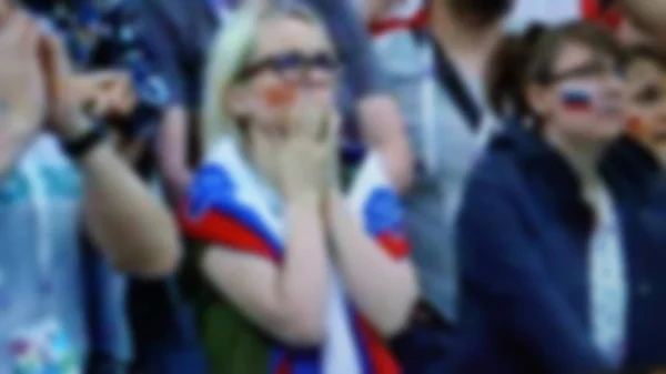 Football supporters at the stadium -Football fans having fun and looking at football match . Blurred view