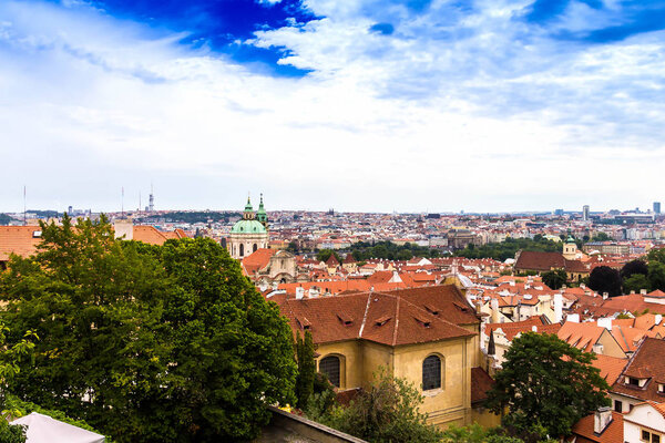 Summer aerial view of the Old Town architecture with red roofs and church of Saint Nicholas in Prague , Czech Republic.