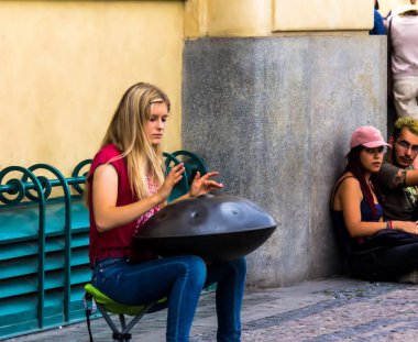 Prague, Czech Republic -July 23,2017: Young woman playing on a first generationan instrument called '' Hang '' or ''Hang drum''