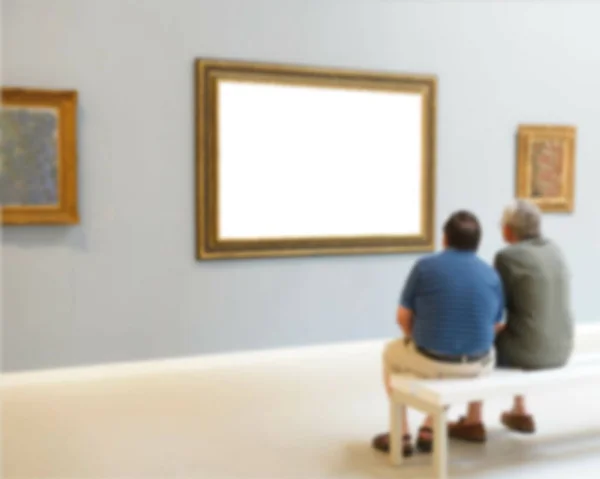 Two visitors look at paintings in one of halls of Art Museum