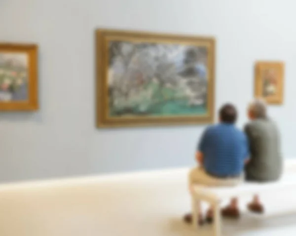 Two visitors look at paintings in one of halls of Art Museum