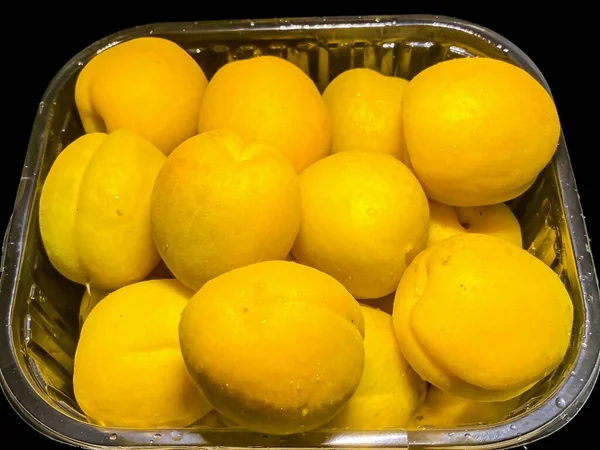 Abricots Jaunes Dans Emballage Boîte Plastique Isolé Sur Fond Noir — Photo