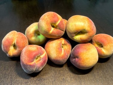 Koyu kahverengi ahşap masada taze kırmızı şeftaliler