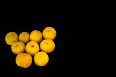 Siyah arkaplanda büyük sarı erikler