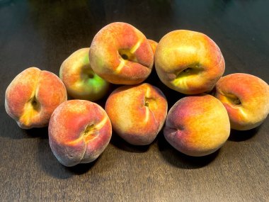 Koyu kahverengi ahşap masada taze kırmızı şeftaliler