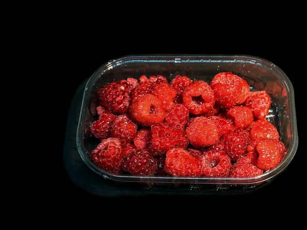 Rote Himbeeren Kunststoffverpackung Box Isoliert Auf Schwarzem Hintergrund — Stockfoto