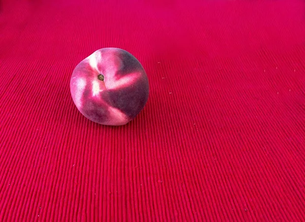 Ένα Φρέσκο Κόκκινο Ροδάκινο Κόκκινο Πανί Χαρτοπετσέτα Ένα Τραπέζι — Φωτογραφία Αρχείου
