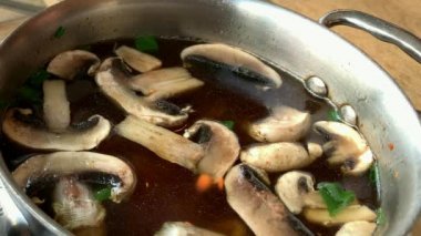 Mantarlı sıcak Japon çorbası, erişte ve metal bir tavada tofu. 4K