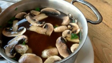 Mantarlı sıcak Japon çorbası, erişte ve metal bir tavada tofu. 4K