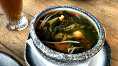 Büyük seramik kasede Miso çorbası. Geleneksel Japon yemeğidir. Ana malzemeler miso macunu, tofu, wakame deniz yosunu ve shiitake mantarı..