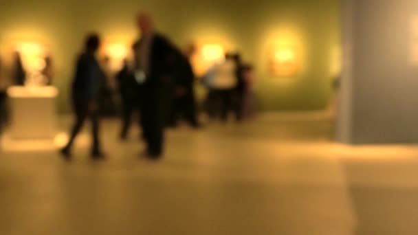 アートギャラリーの展覧会の訪問中に歩く人々のビュー 意図的なぼかし効果が適用される背景 — ストック動画