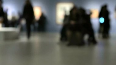 Sanat galerisi ziyareti sırasında yürüyen insanların görüntüsü. Bilinçli bulanık efektli arkaplan