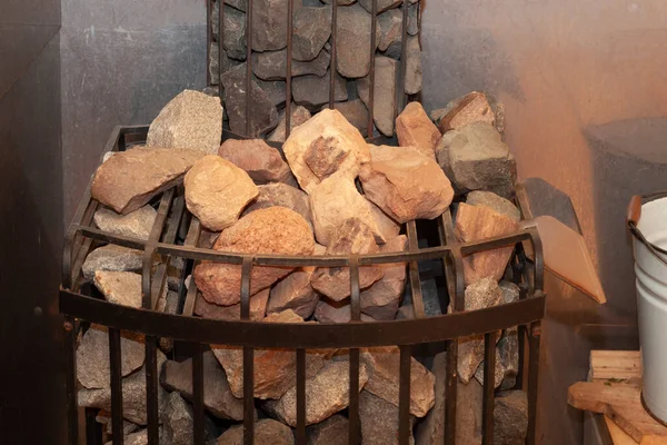 Hot stones in the sauna bath - Finnish sauna. Stones in the sauna heater close-up. Stones for heating the air in the bath