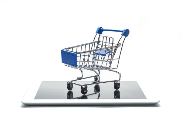 デジタル タブレットやスマート フォンの白い背景で隔離の空の金属のショッピングカート コマースやオンライン ショッピングのコンセプト イメージ — ストック写真