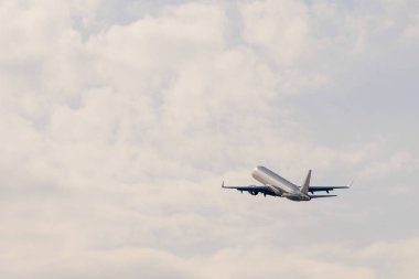 Bir hava planı gün batımında bulutlara doğru gider.