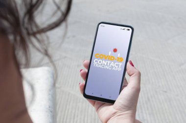 Coronavirüs 'ten salgını önlemek için Covid-19 izleme uygulaması kullanan bir kadın.