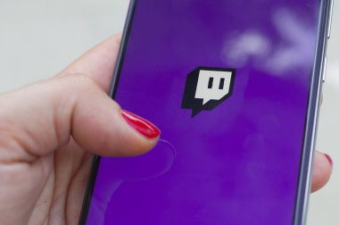 Carrara, İtalya - 6 Temmuz 2020: Kadın açık havada akıllı telefondan Twitch uygulaması çalıştırıyor. Twitch, Amazon 'un sahip olduğu canlı yayın platformu.