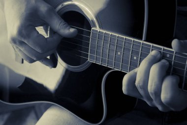 Akustik gitar çalan bir adamın ayrıntıları, duotone rengi