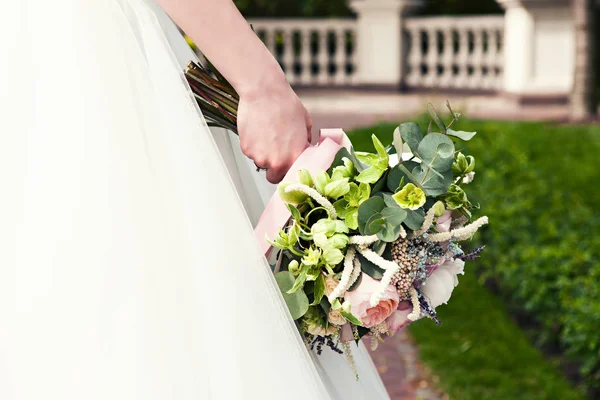 Bruden håller en brudbukett, bröllopsklänning, bröllop Detaljer. Bröllop ceremoni koncept. — Stockfoto