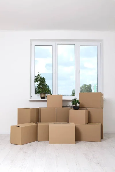 Moving into a new apartment. Move lots of cardboard boxes in an empty new apartment.