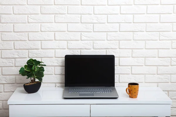 Witte tabel in de buurt van de witte muur. Lege werkplek in de kamer. Witte achtergrond. — Stockfoto