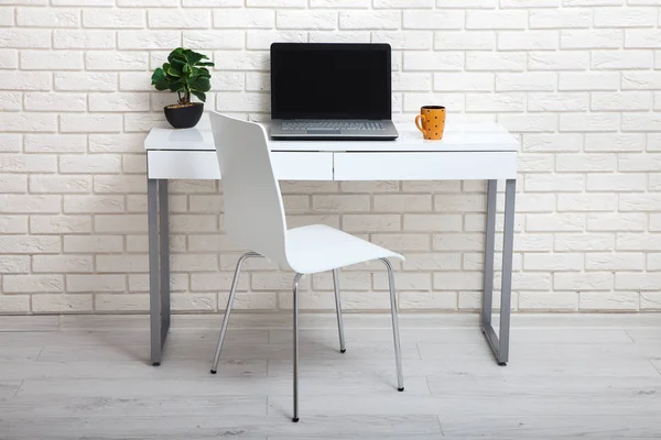 Witte tabel in de buurt van de witte muur. Lege werkplek in de kamer. Witte achtergrond. — Stockfoto