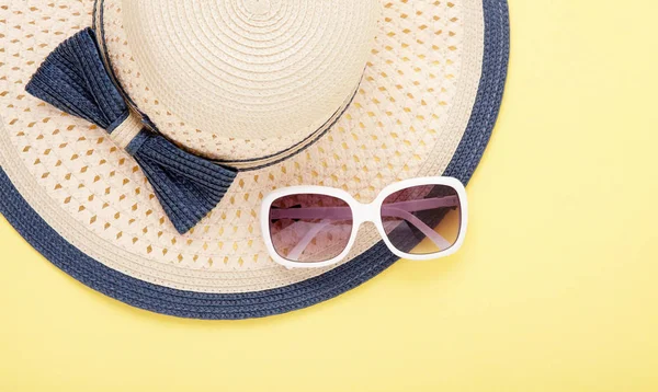 Topi musim panas dengan pita dan kacamata hitam diisolasi dengan latar belakang berwarna-warni. Ruang salin dan tampilan atas . — Stok Foto