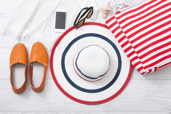 Καλοκαιρινό αξεσουάρ καπέλο και τσάντα σε άσπρο φόντο ξύλινη. — Φωτογραφία Αρχείου